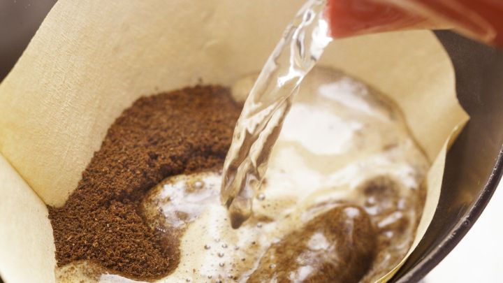 Kaffee wird frisch zubereitet, w&auml;hrend hei&szlig;es Wasser &uuml;ber gemahlenen Kaffee in einem Filter gegossen wird.