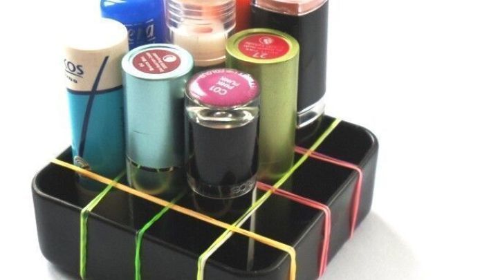Eine Box mit Gummiband-Aufteilung h&auml;lt verschiedenfarbige Fl&auml;schchen geordnet und stabilisiert sie in einem kompakten Raum.