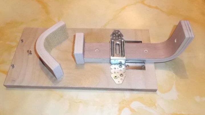 Ein einarmiges K&uuml;chenger&auml;t h&auml;lt Lebensmittel sicher, w&auml;hrend es auf einer hellen Arbeitsplatte zum Zubereiten verwendet wird.