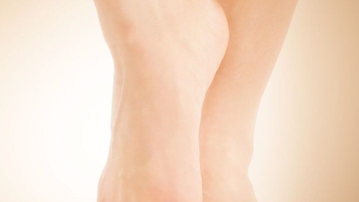 Zwei sch&ouml;ne F&uuml;&szlig;e stehen eng beieinander, umgeben von einem weichen, hellen Hintergrund, der die Aufmerksamkeit auf die Haut lenkt.