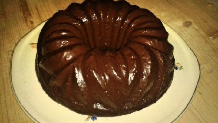 Ein saftiger Nuss-Schoko-Kuchen liegt auf einem wei&szlig;en Teller und verstr&ouml;mt einen k&ouml;stlichen Duft in einer gem&uuml;tlichen K&uuml;che.