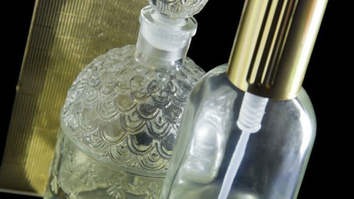 Klarer Fl&uuml;ssigkeitsbeh&auml;lter und ein dekorativer Zerst&auml;uber stehen zusammen auf einem glatten Untergrund, um Hundekot abzuschrecken.