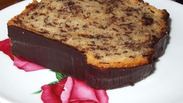 Schokokuchen mit fester Schokoglasur liegt auf einem Teller mit Rosenmotiv.