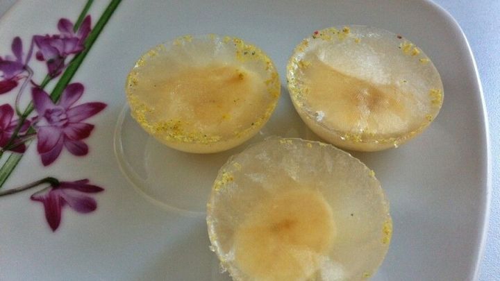 Eisw&uuml;rfel Leckerlie in Form von gefrorenen Fruchtst&uuml;cken, arrangiert auf einem blumenverzierten Teller.