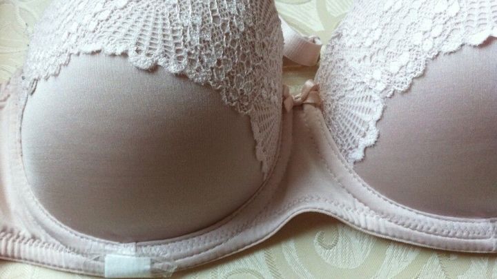 Ein BH mit einer zarten Spitze liegt auf einer hellen, gemusterten Oberfl&auml;che, zeigt eine elegante, bequeme Form.