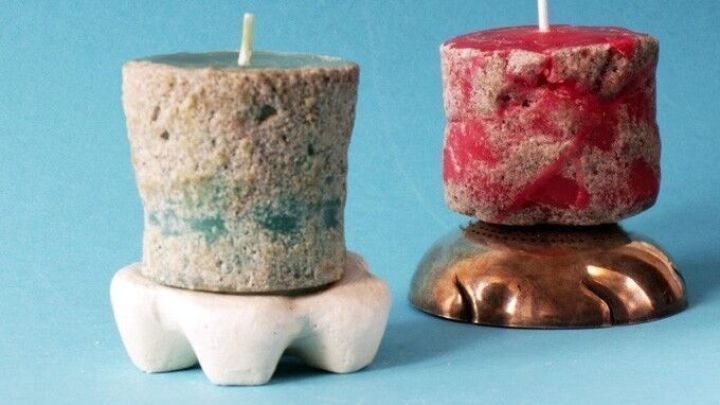 Bunte Sandkerzen stehen auf einem hellen Untergrund, w&auml;hrend sie fr&ouml;hlich im Licht leuchten und f&uuml;r Stimmung sorgen.