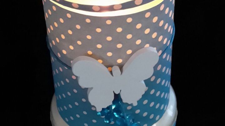 Ein dekorativer Kerzenhalter mit einem blauen und wei&szlig;en Design strahlt sanftes Licht aus, ideal f&uuml;r Balkon oder Terrasse.