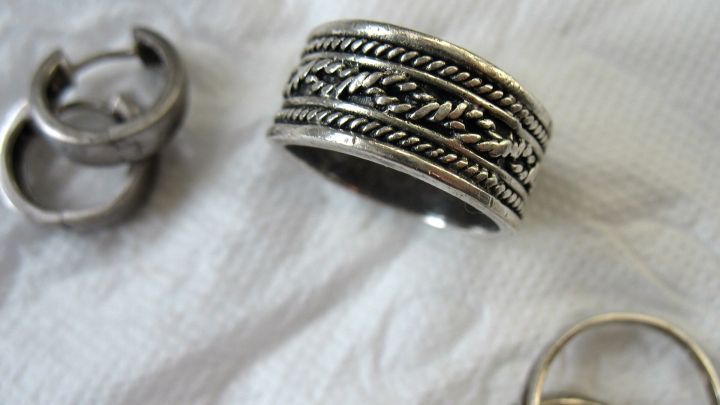 Silberschmuck liegt auf einem weißen Tuch, während zwei Ringe und ein detaillierter Ring zur einfachen Reinigung bereitliegen.
