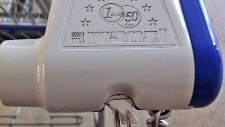 Ein Schl&uuml;ssel wird als Einkaufswagenchip verwendet, um den Wagen im Supermarkt freizugeben. Der Einkaufswagen steht bereit.