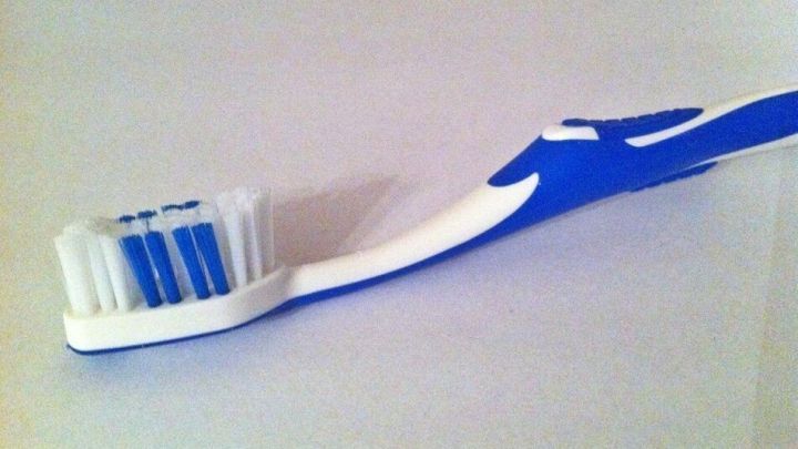 Eine Zahnb&uuml;rste liegt auf einem wei&szlig;en Untergrund, bereit, um die Z&auml;hne perfekt zu putzen und f&uuml;r Mundhygiene zu sorgen.