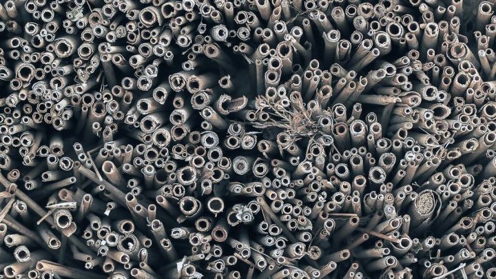 Eine Vielzahl von R&ouml;hren und Nisthilfen f&uuml;r Wildbienen liegt eng beieinander, bereit zur Nutzung im Garten oder Natur.