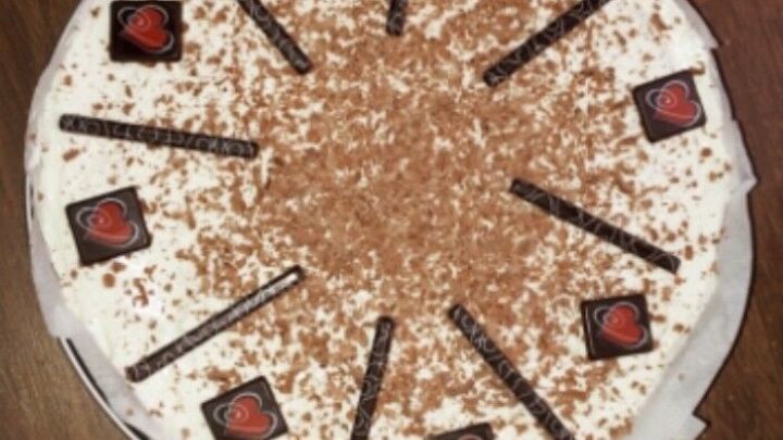 Eine k&ouml;stliche Torte mit frischer Sahne, dekoriert mit Schokoladenst&uuml;cken und Schokoladenraspeln, perfekt f&uuml;r einen Muttertag.