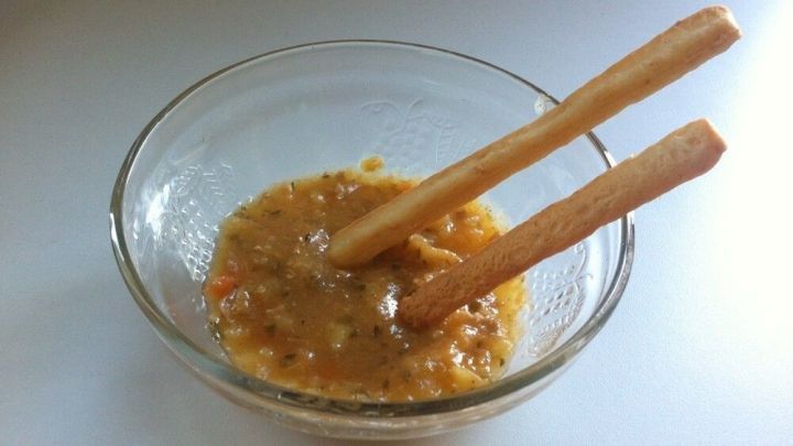 Ein Glassch&uuml;ssel enth&auml;lt eine Mischung aus Suppenr&uuml;ckst&auml;nden und Eint&ouml;pfen, die mit zwei Holzst&auml;bchen verr&uuml;hrt wird.