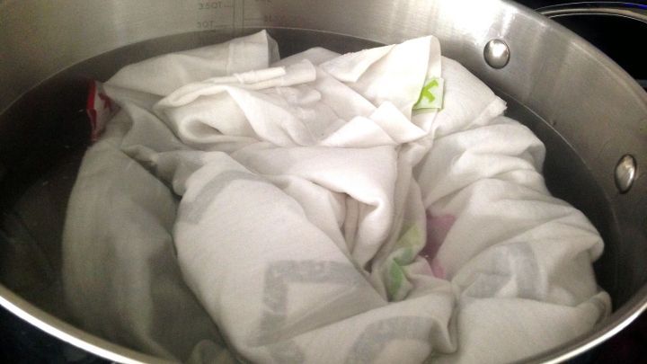 Ein kochender Topf mit einem Haufen W&auml;sche, die zur Entfernung von Verf&auml;rbungen im Wasser eingeweicht wird.