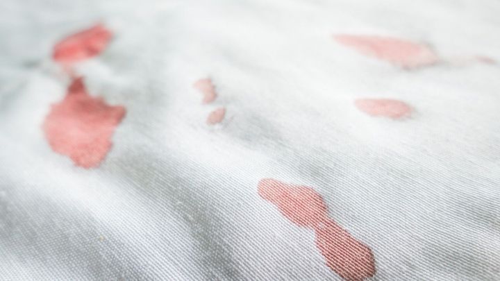 Ein wei&szlig;es Stoffsofa mit frischen Blutflecken zeigt das Problem, das beim Reinigen behandelt werden muss.