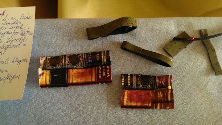 Auf einem B&uuml;geltisch liegen mehrere Kleinteile, die in verschiedenen Positionen angeordnet und festgesteckt sind.