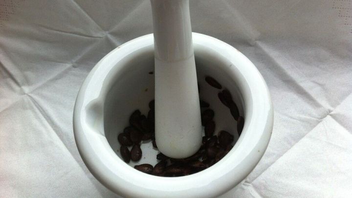 Ein M&ouml;rser mit Wassermelonenkerne wird zum Mahlen verwendet, um die Verdauung zu f&ouml;rdern, vor einem wei&szlig;en Hintergrund.