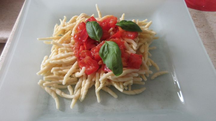 Frische, geschmolzene Tomaten auf ligurischen Trofie-Nudeln, verfeinert mit Basilikum &ndash; ein einfaches Sommergericht aus Italien.