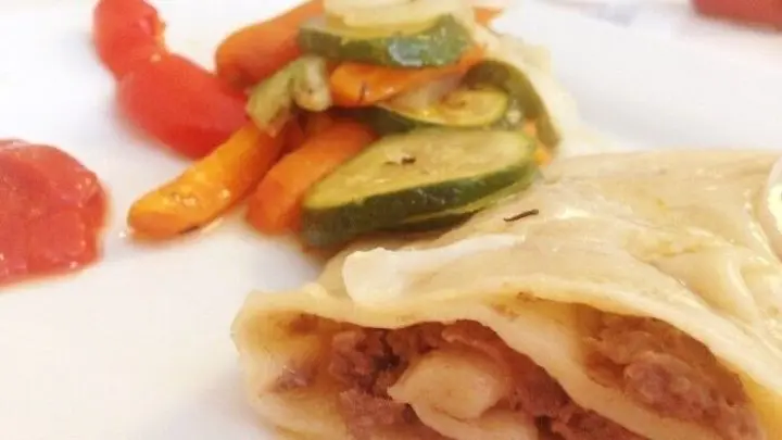 Fertig ged&uuml;nstete Nudelrolle mit Hackfleisch-Knoblauchf&uuml;llung, Ofengem&uuml;se und Paprika-Tomaten-Knoblauchso&szlig;e.