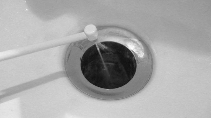 Eine Munddusche spritzt Wasser in den Abfluss, um ihn zu reinigen und Verstopfungen zu l&ouml;sen.