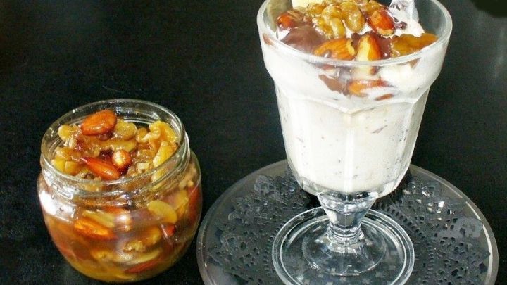 Ger&ouml;stete N&uuml;sse sind in einer Dessertsch&uuml;ssel mit Honig und einer Eisschicht, serviert auf einem eleganten Teller.