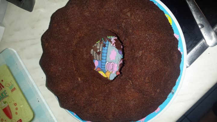 Ein Low-Carb Schokokuchen steht auf einem bunten Teller in einer K&uuml;che, umgeben von einer Arbeitsplatte und einem Messer.