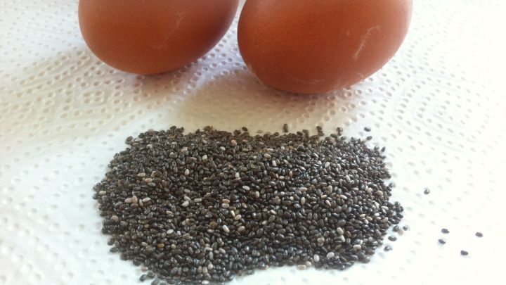 Braune Eier liegen neben schwarzem Chiasamen auf einem K&uuml;chenpapier, das f&uuml;r Ei-Ersatz beim Backen verwendet wird.