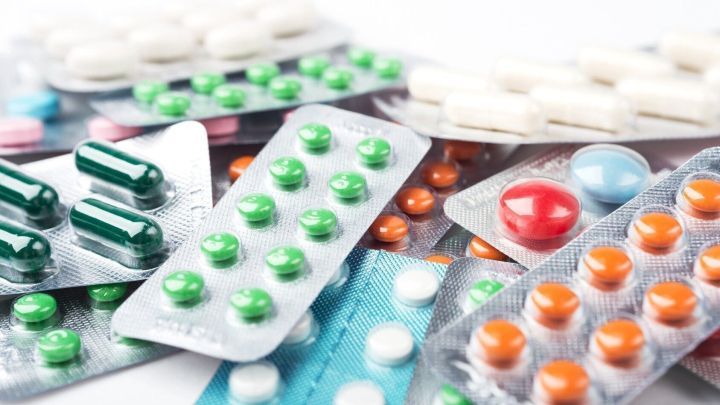 Bunte Pillen und Tabletten liegen verstreut auf einem Tisch und symbolisieren den Medikamentenentzug und m&ouml;gliche Herausforderungen.