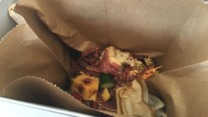 Im inneren eines Bioeimers liegt eine Mischung aus Essensresten, um Fruchtfliegen zu vermeiden, in Pappe eingewickelt.