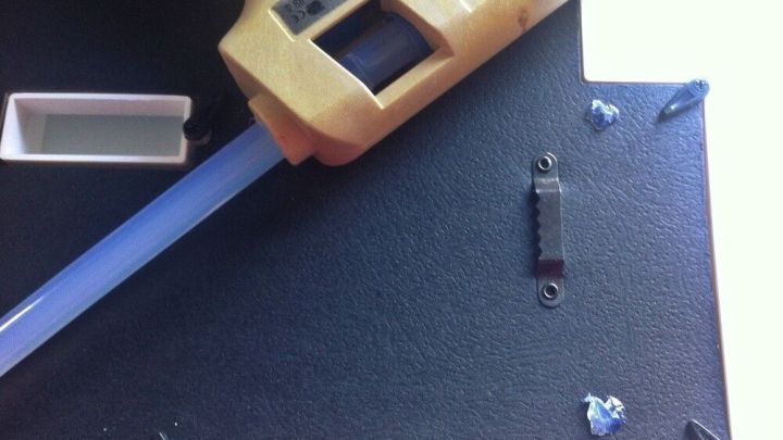 Eine Hei&szlig;klebepistole liegt auf einer schwarzen Oberfl&auml;che und ist bereit, um Kleber aufzutragen, ideal f&uuml;r Bastelprojekte.