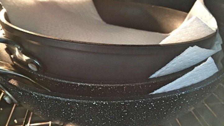 Stapelte Bratpfannen mit sch&uuml;tzenden Papiert&uuml;chern im Inneren, um Kratzer beim Lagern zu vermeiden.