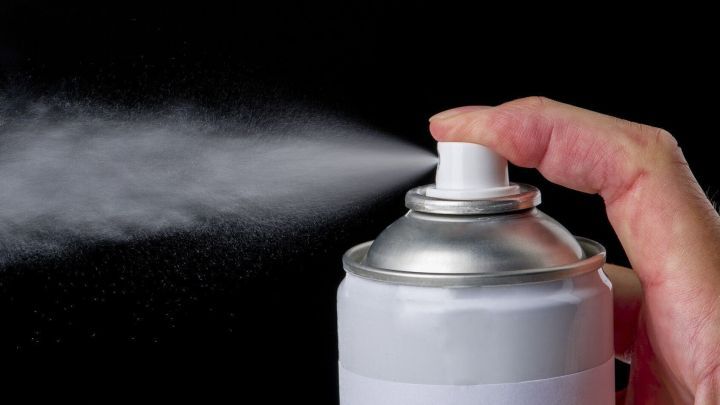 Ein Hand spr&uuml;ht aus einer Spraydose, die m&ouml;glicherweise zum Entfernen von Farbe wie Fingermalfarbe verwendet wird.