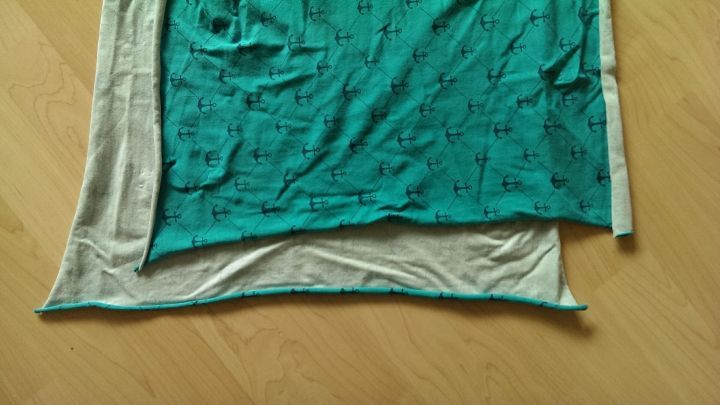 Ein farbiger Jersey liegt quer auf einem hellen Untergrund, wobei die rechte Seite sichtbar und in Verwendung ist.