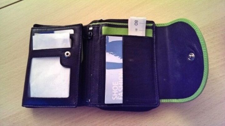 Ein Ma&szlig;band liegt in einer offenen Geldb&ouml;rse, umgeben von Kartenf&auml;chern, bereit f&uuml;r den schnellen Gebrauch unterwegs.