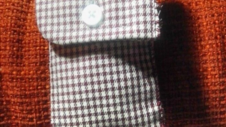 Ein gestreiftes, braunes Stoffst&uuml;ck liegt auf einem orangefarbenen Untergrund und dient als praktische Aufbewahrung.