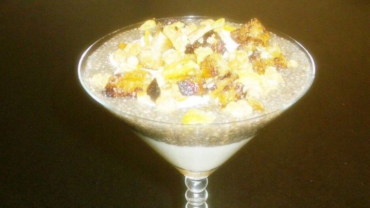 Kleine, s&uuml;&szlig;e Brotw&uuml;rfel liegen um ein filigranes Glas mit einer cremigen Nachspeise, das verlockend dekoriert ist.