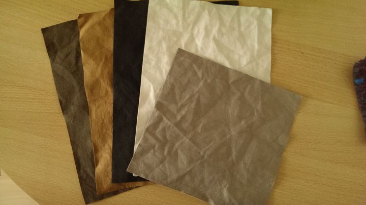 Verschiedene SnapPap-Muster liegen auf einem Tisch, die veganes Leder in verschiedenen Farben zeigen.