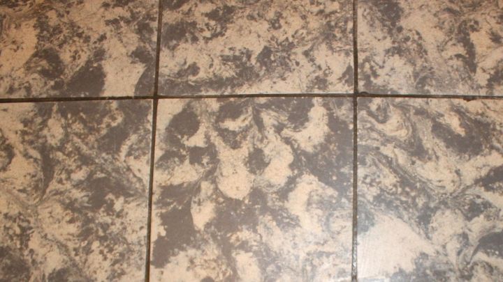 Geklebte Auslegware liegt auf einem Boden, w&auml;hrend Reste vorsichtig entfernt werden, um den darunterliegenden Untergrund freizulegen.