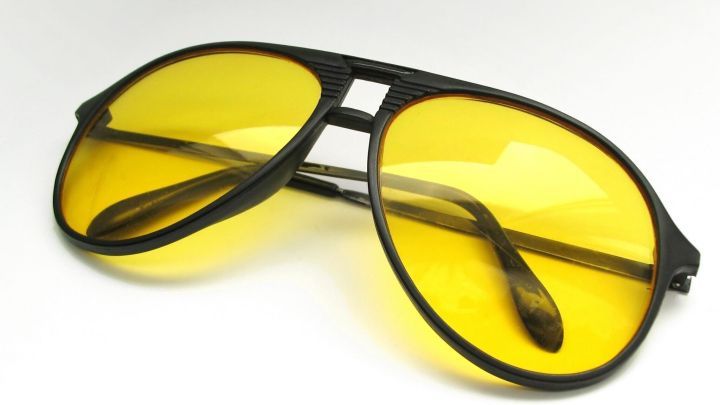 Gelbe Brillengl&auml;ser liegen auf einem Tisch, die helfen k&ouml;nnten, beim Autofahren in der Dunkelheit besser zu sehen.