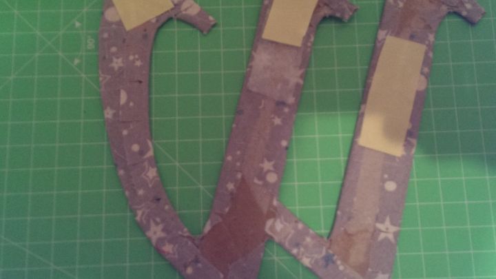 Den fertigen Buchstaben (viel sp&auml;ter bei der endg&uuml;ltigen Dekoration) mit doppelseitigem Klebeband am Kranz befestigen