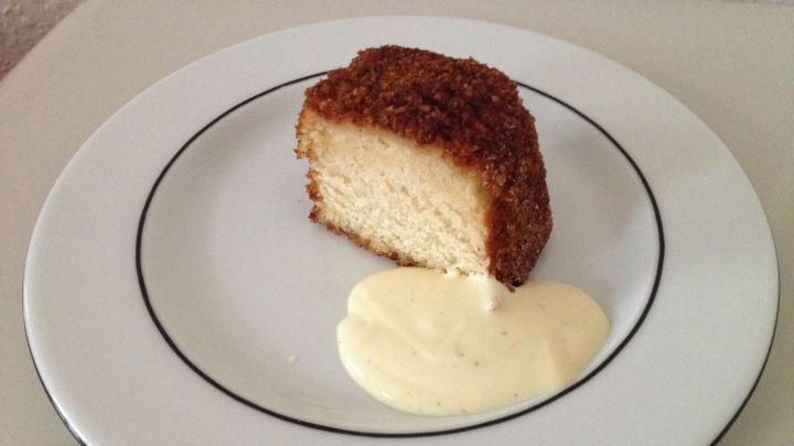 Ein Karth&auml;user Klo&szlig; liegt auf einem Teller und wird mit einer cremigen Vanilleso&szlig;e serviert. Der Klo&szlig; ist goldbraun.