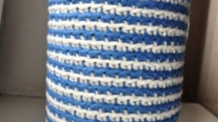 Ein blau-gestreifter Topflappen-Stulpen umh&uuml;llt ein Schraubglas und steht auf einer wei&szlig;en Oberfl&auml;che.