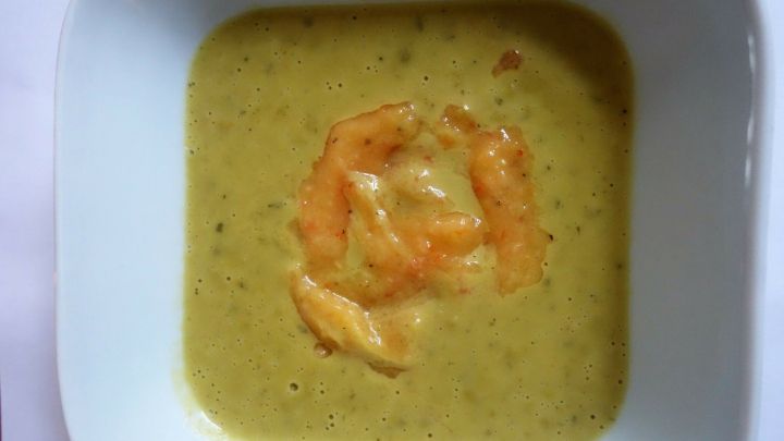 Eine gr&uuml;ne Erbsen-Estragon-Suppe mit Mangodip befindet sich in einer wei&szlig;en Sch&uuml;ssel, umgeben von einem neutralen Hintergrund.