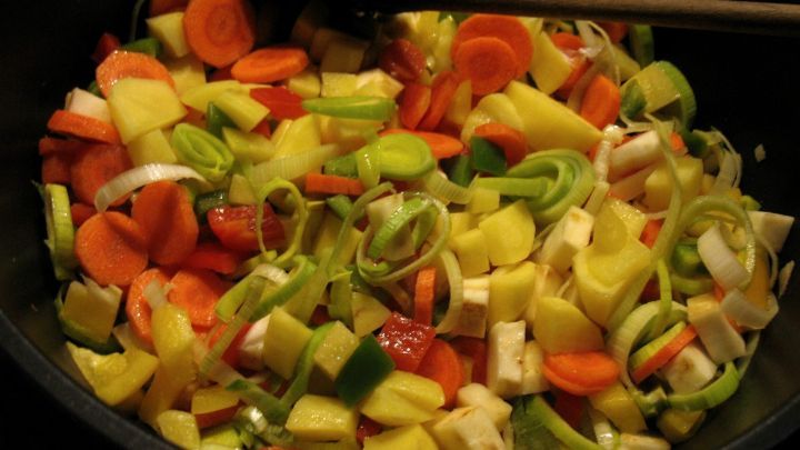 Bunte Gem&uuml;sest&uuml;cke werden in einem gro&szlig;en Topf vermischt, bereit f&uuml;r einen kr&auml;ftig-w&uuml;rzigen Eintopf mit Gnocchi.