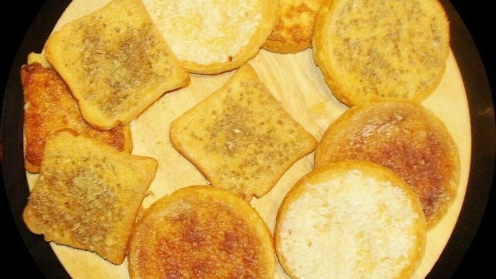 Zarte Zwieback-St&uuml;cke aus Kokos, Anis und Zimt liegen auf einem Holzbrett und laden zum Verzehr ein.