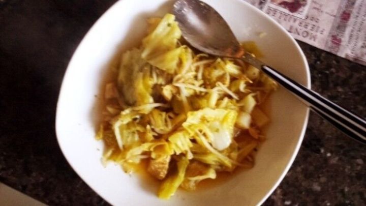 Eine Sch&uuml;ssel mit Jaromakohl-Suppe steht auf einem Tisch, w&auml;hrend ein L&ouml;ffel dazwischen ruht und die Suppe wartet.