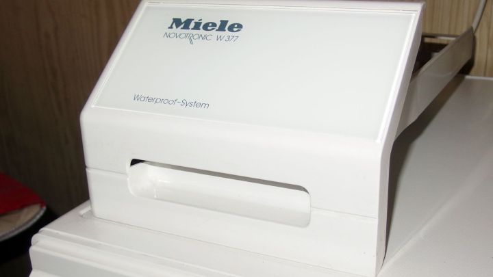 Ein Waschmittel-Einsp&uuml;lkasten steht sauber und ordentlich auf einer Waschmaschine, um Schimmel im Innenraum zu verhindern.