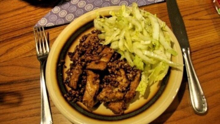 H&auml;hnchenbrustfiletstreifen liegen auf einem Teller, garniert mit einem Salat aus geschnittenem Kopfsalat.