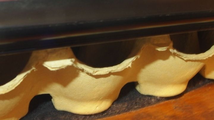 Ein Laptop liegt auf einem Untergrund aus Eierkartons, der Hitze isolation bietet, um &Uuml;berhitzung zu vermeiden.