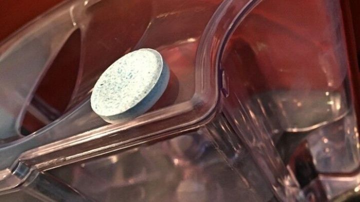 Eine Kaffeemaschine mit einem Reinigungstablette in einem Wassertank, bereit f&uuml;r die Reinigung.